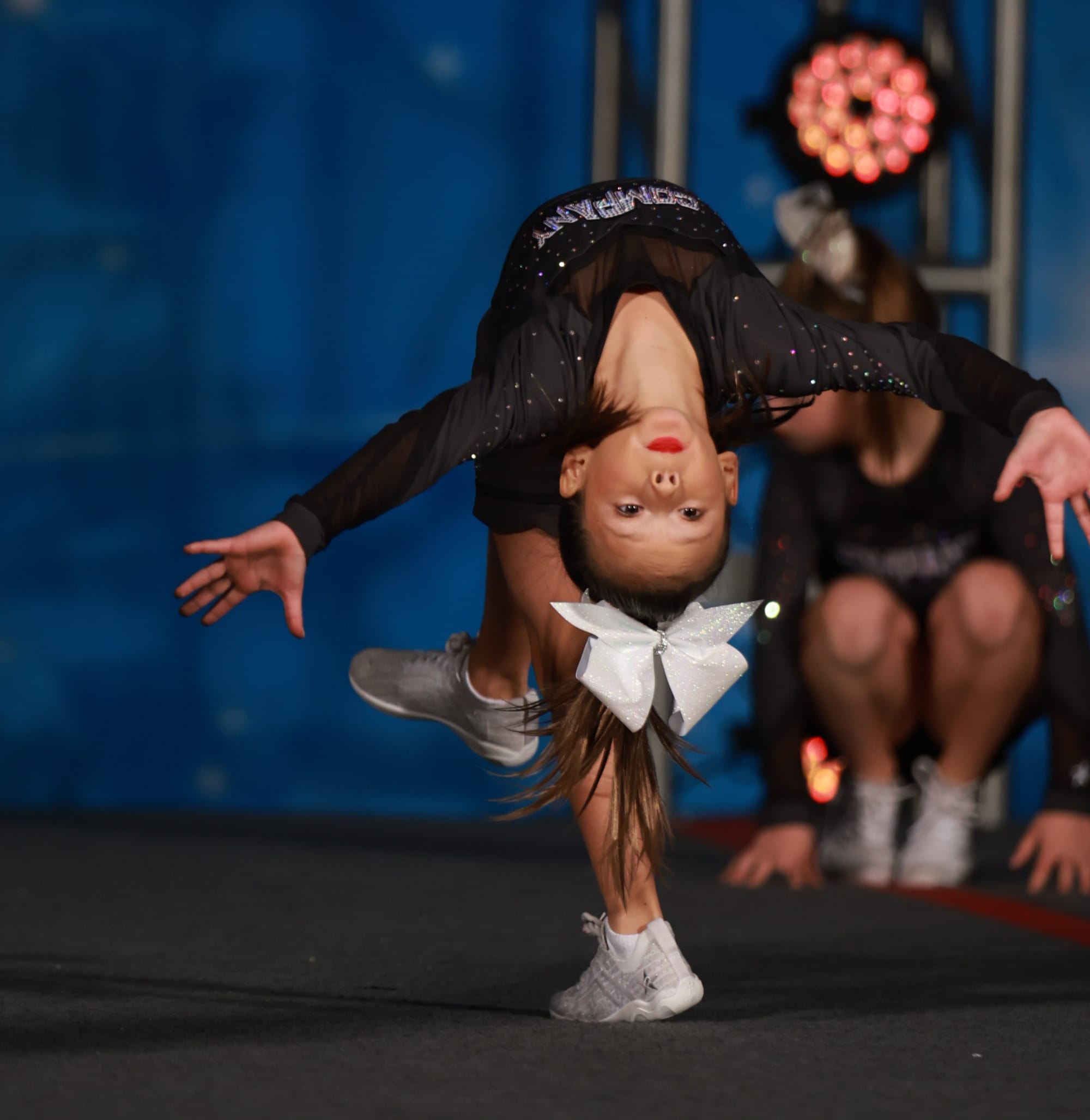 Young dancer performing a backbend in a black sparkly outfit